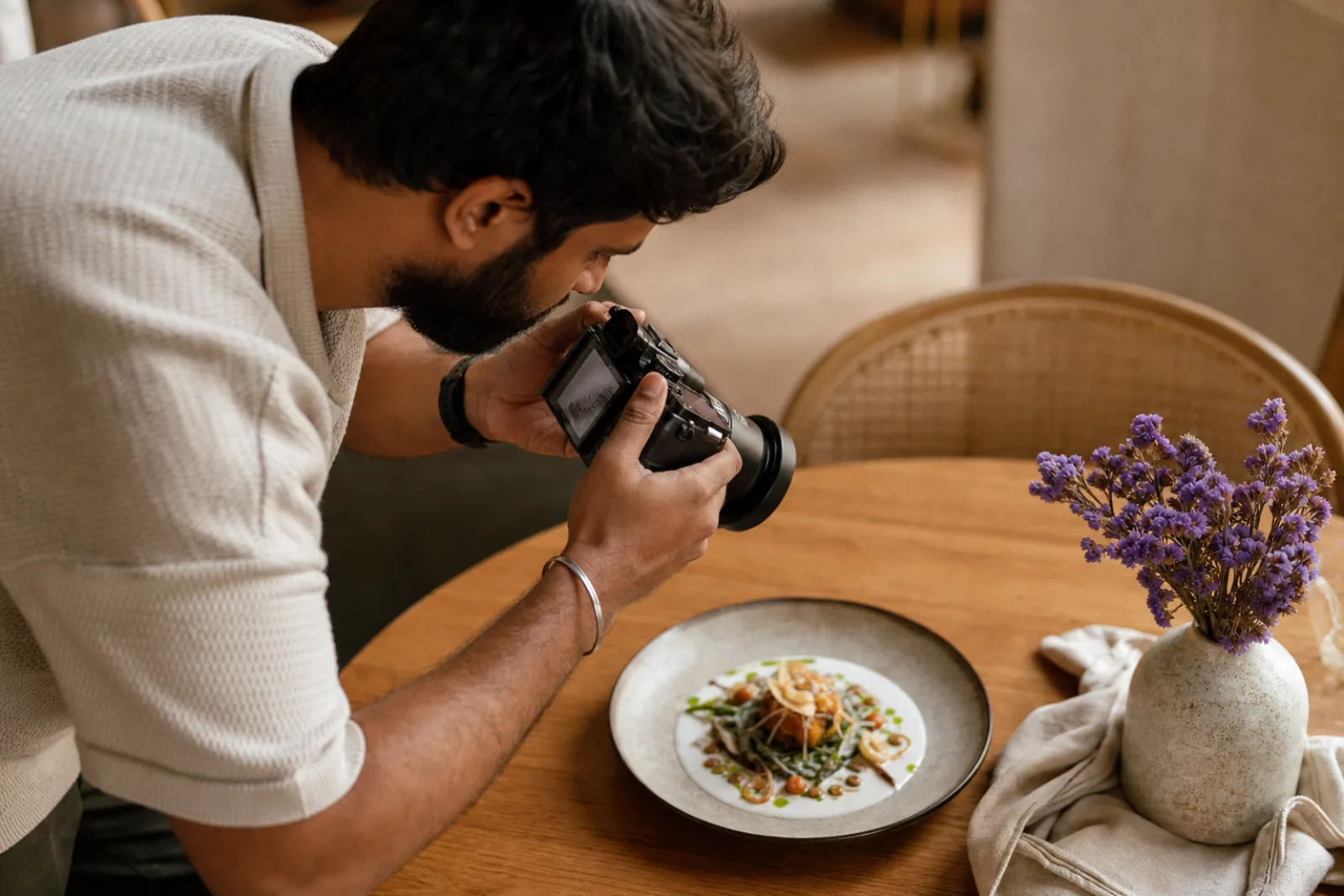 A creator photographing a plated dish overhead in a restaurant